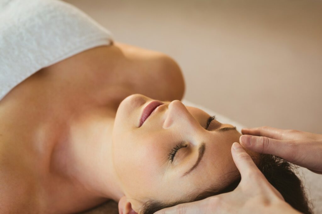 Young woman having a reiki treatment in therapy room